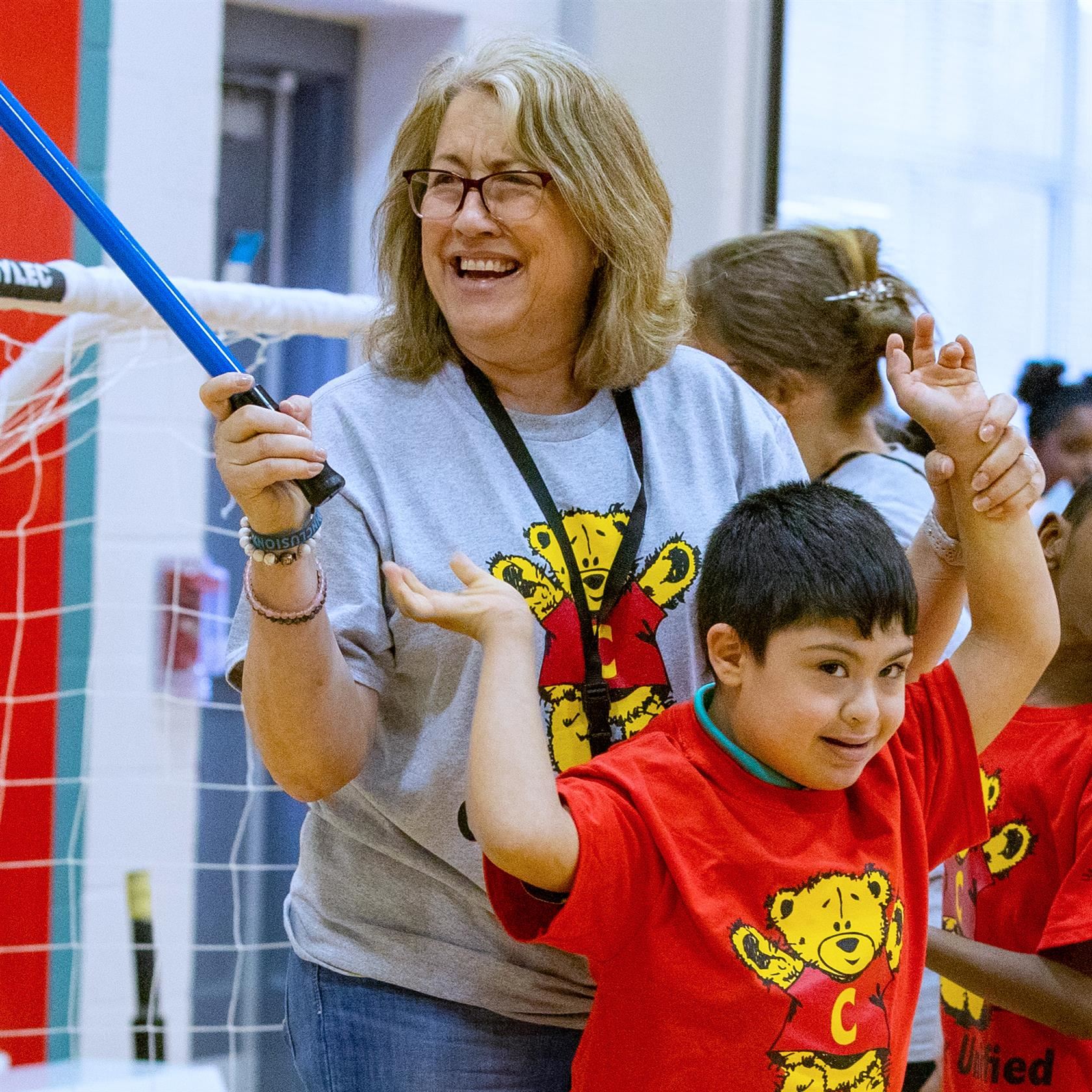  Teacher smiles while helping student with gym equipment